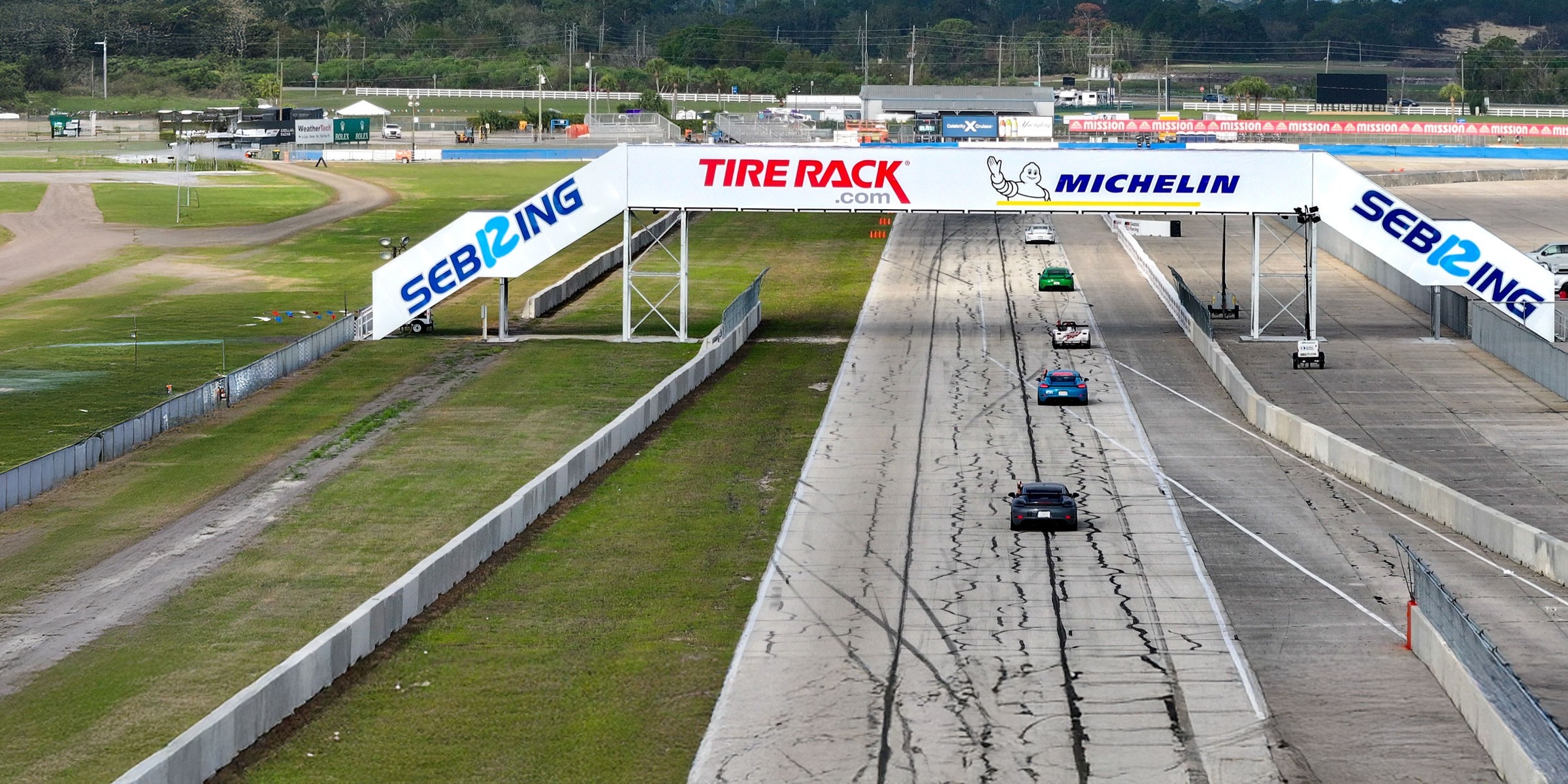 Race cars on a track passing underneath the Sebring International Raceway Bridge