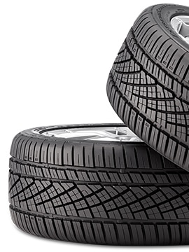 Two Continental ExtremeContact DWS 06 tires stacked at an angle, showing asymmetric tread pattern for all-season performance.