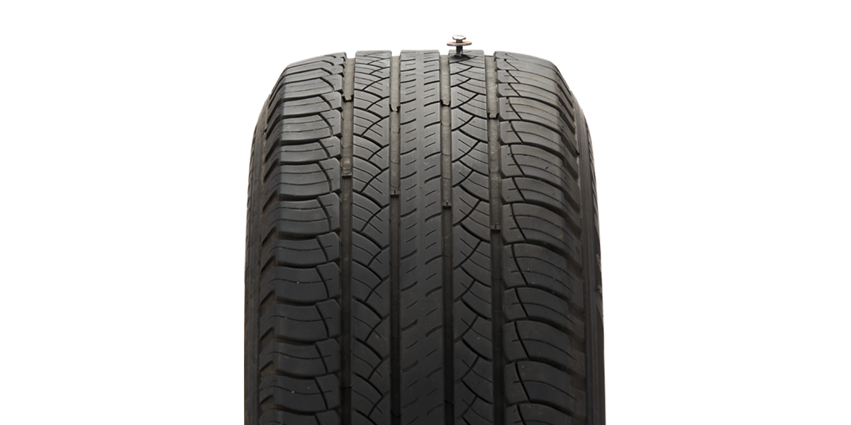 Close-up of a tire with a bolt in the tread, representing Free Two-Year Road Hazard Protection built in