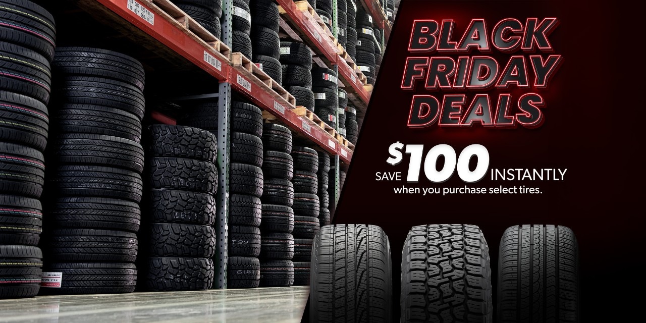 Black Friday Deals: Save $100 Instantly when you purchase select tires overlaying tires stacked in a warehouse