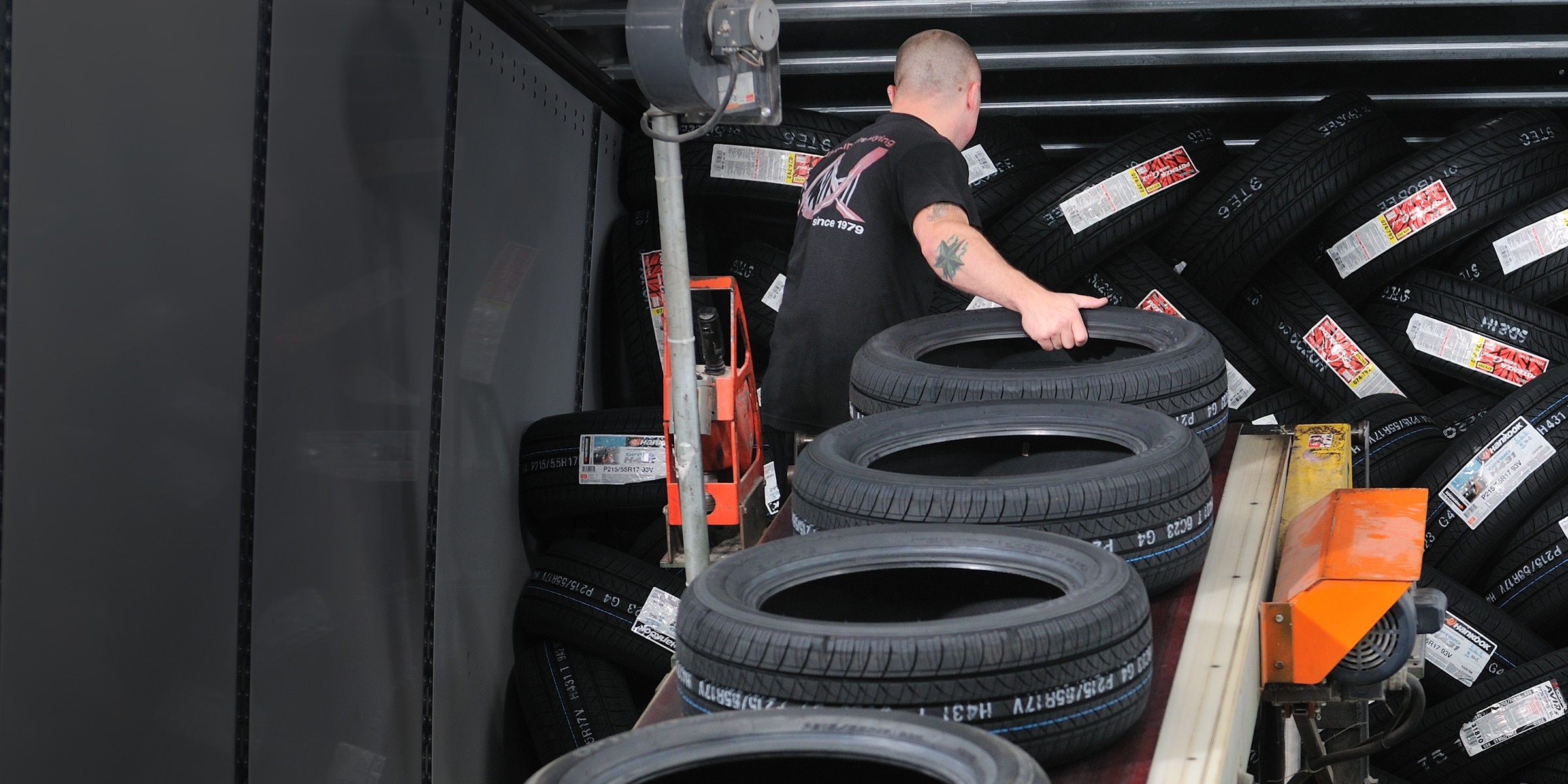 Worker unloading tires from a delivery truck, representing Tire Rack’s direct-to-installer tire shipping and convenient installation appointments.