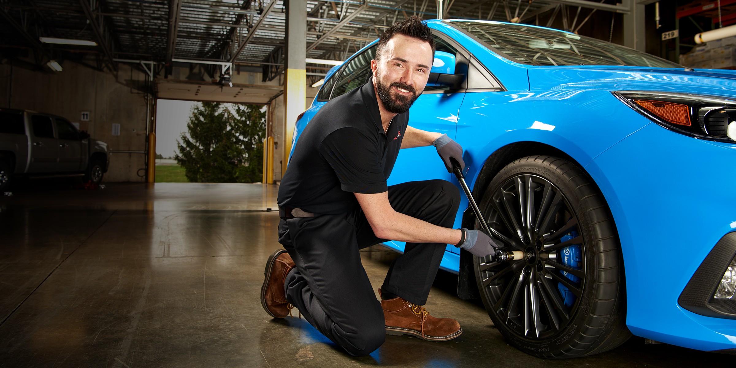 Technician mounting a tire and wheel on a car at a Tire Rack Recommended Installer.