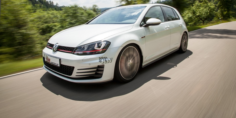 White Volkswagen Golf GTI driving on the road with KW suspension