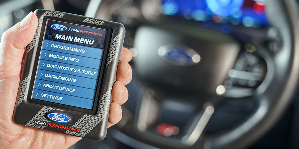 Closeup of hand holding a Ford Performance brand Engine Tuning Device