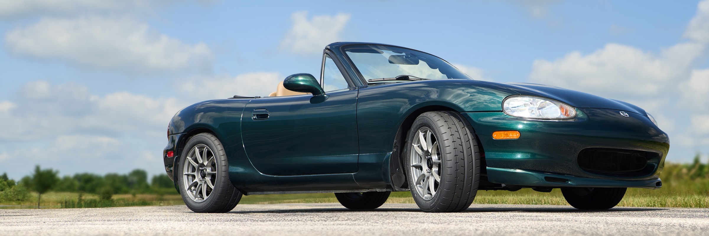 Mazda Miata convertible fitted with Yokohama Advan A052 tires on a road.