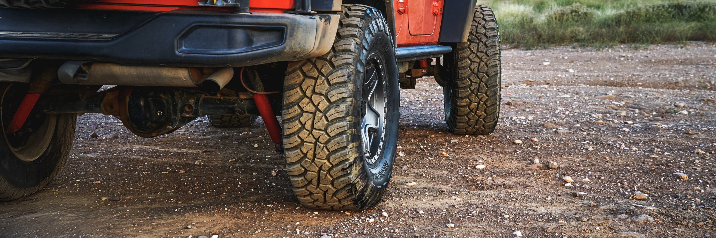 Rear wheel close-up showing a General Grabber all-terrain tire on a lifted truck.