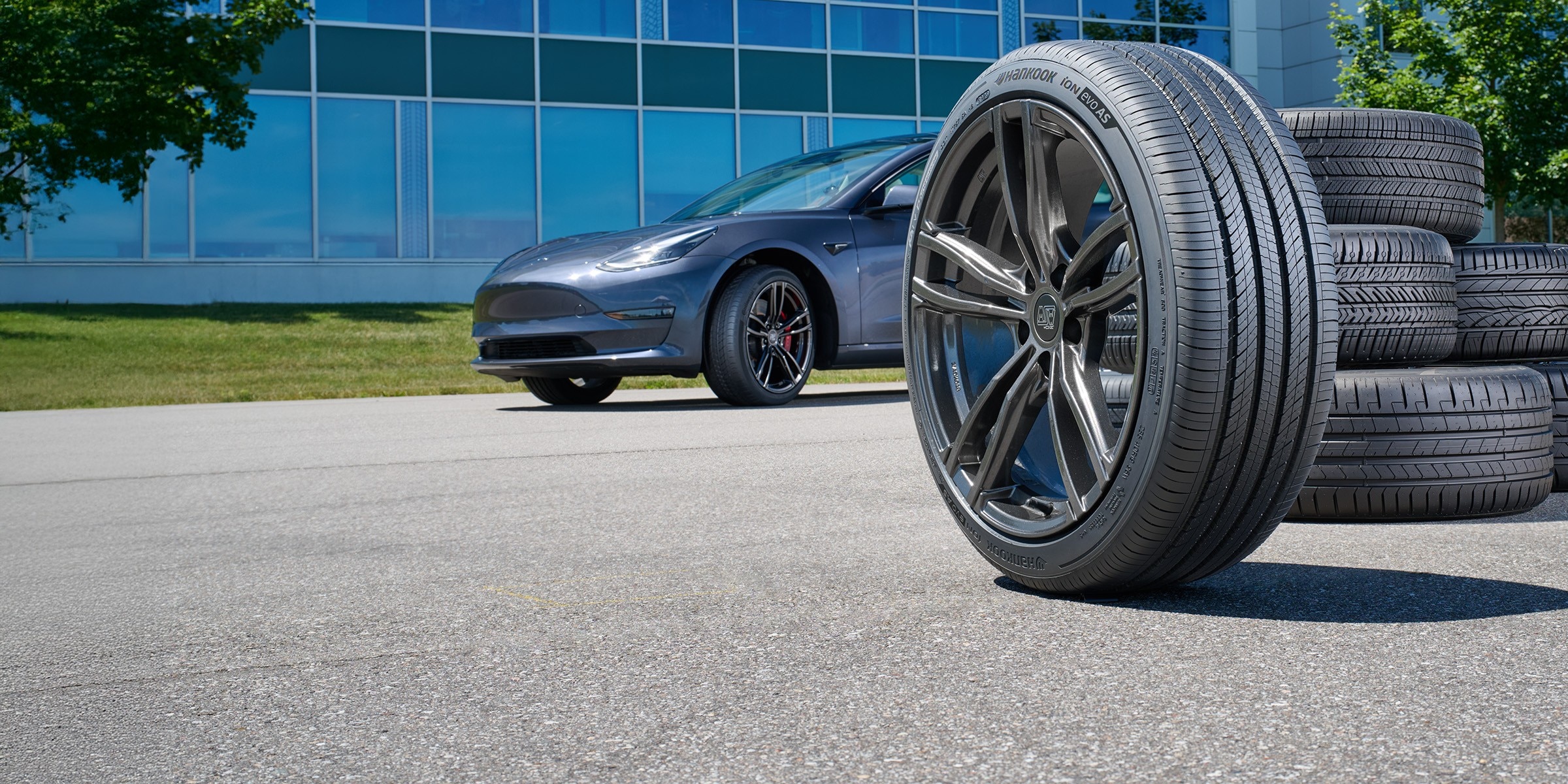 Hankook iON evo AS tire on MSW Type 73 wheel with a Tesla Model 3 and tire group in the background.
