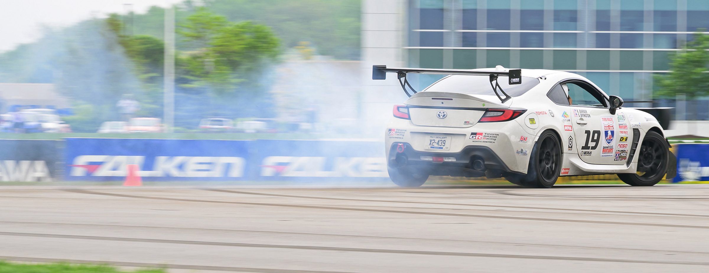 Drift Tires portrayed on a car driving around a race track, with smoke billowing behind the car.