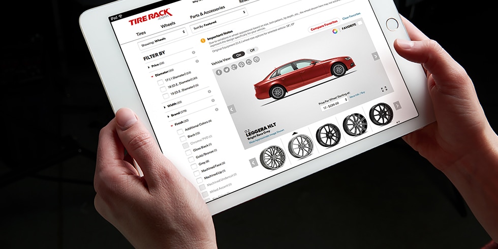 Hands holding an iPad showing the Tire Rack wheel visualizer with a Flow One F2 wheel carousel on a red BMW 428i.