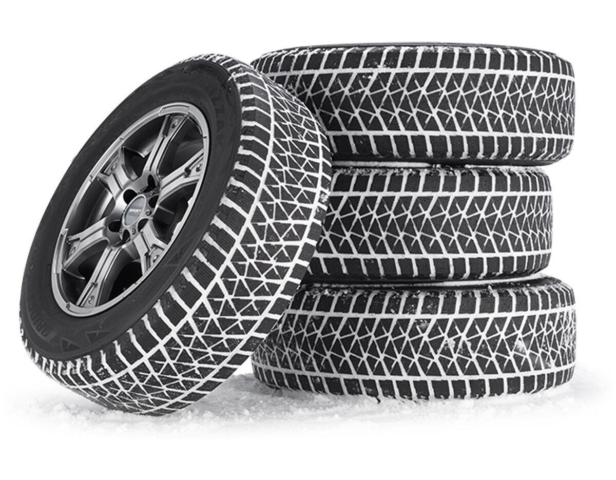 A stack of 4 winter tires packed with snow