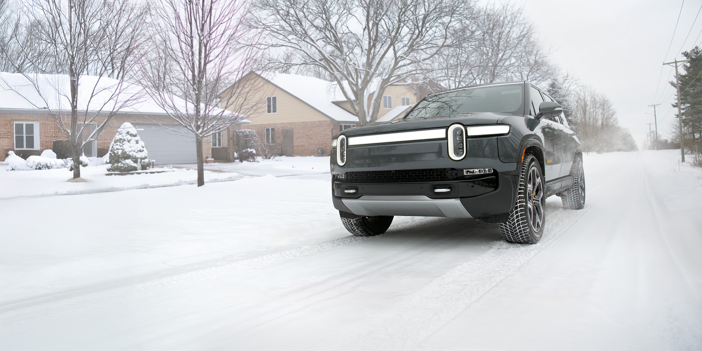 SUV driving through snow-covered street showcasing winter tire traction and snow tire performance.
