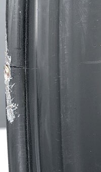 Black wheel with curb damage and bead flange crack